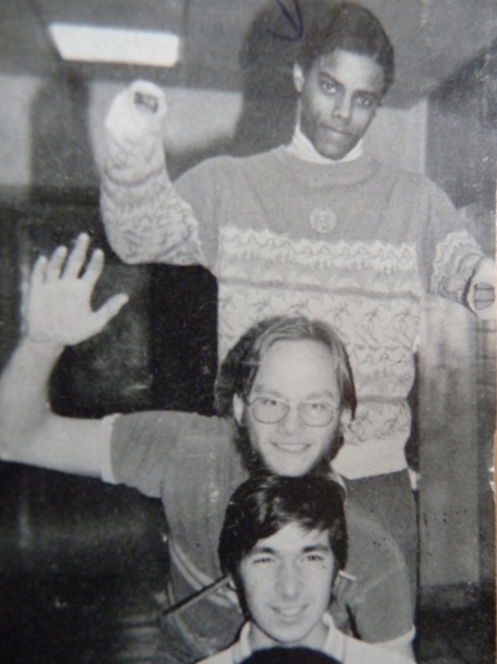 the author in high school, looming behind two other figures from this recollection
